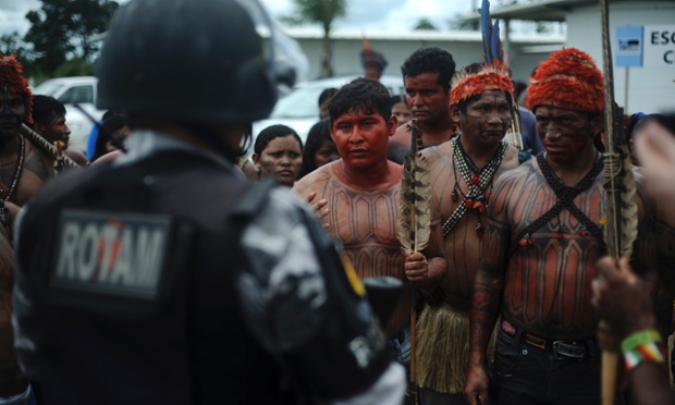 Indiginous people face police officers in Belo Monte