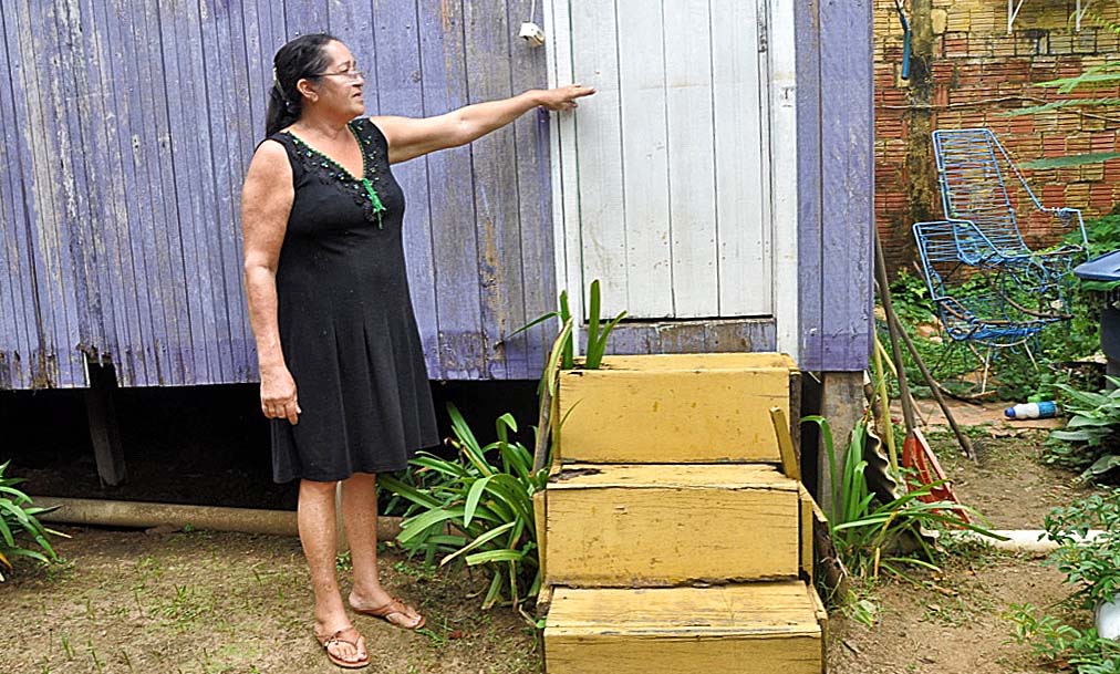 Maria de Jesus mostra a altura que a água alcançou em sua casa na última cheia. Foto: Maria Emília Coelho