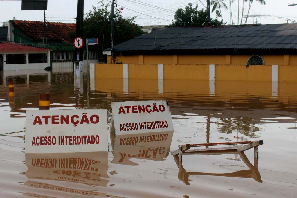Placas de acesso interditado submersas em ruas alagadas durante cheia histórica de 2015 no Acre